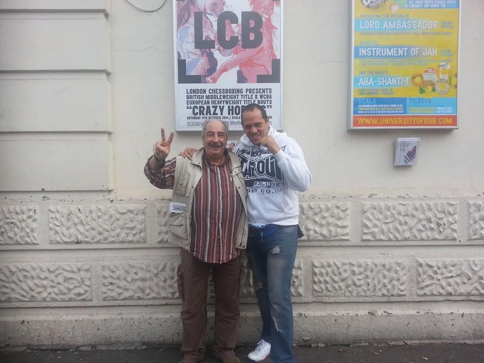 Gianni Burli e Sergio Leveque posano fuori dalla Scala a Londra con il poster dell'evento alle loro spalle.